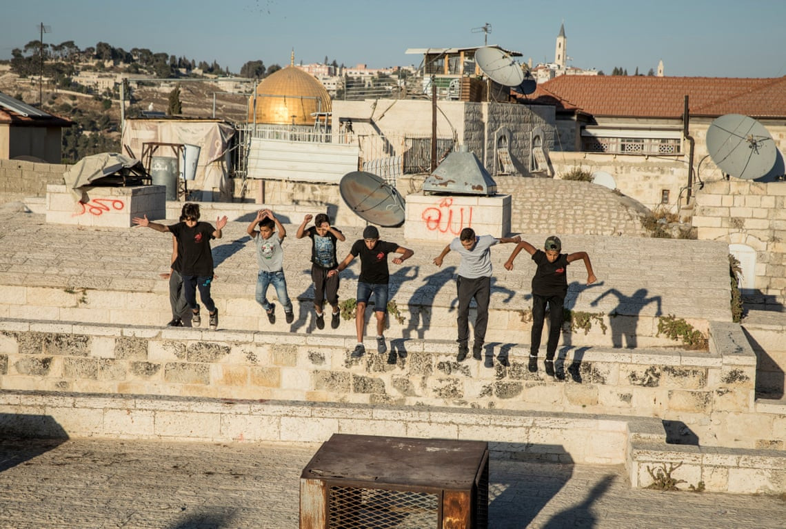 Các bé trai Palestine luyện tập parkour trên sân thượng ở khu thành phố cổ Jerusalem. "Cháu cảm thấy rất tự do khi ở trên sân thượng. Cảnh sát và Lực lượng Phòng vệ Israel (IDF) ít làm phiền hơn", một bé trai cho biết. Ảnh: The Guardian.