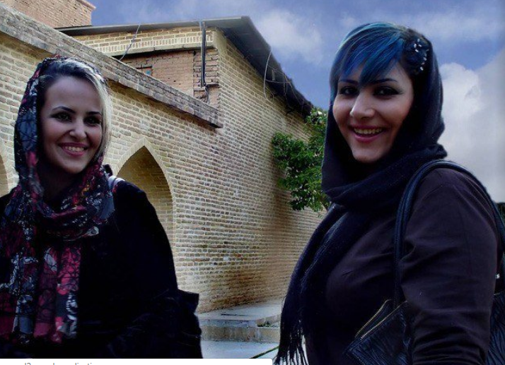 Hai người phụ nữ cười tươi trước ống kính.