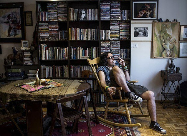 Nghệ sĩ Eylya ngồi hút thuốc trong nhà.