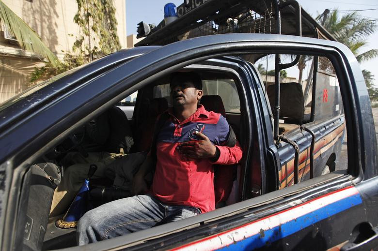 Phóng viên Asif Hassan của hãng thông tấn Pháp ngồi trên xe cảnh sát sau khi bị bắn trúng ngực trong một cuộc biểu tình ở Karachi, Pakistan, ngày 16/1/2015.