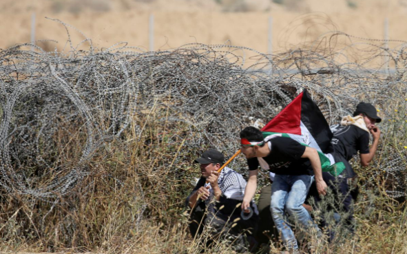 Một số người biểu tình Palestine tìm nơi ẩn nấp trong cuộc đụng độ với lực lượng an ninh Israel ở phía nam Dải Gaza ngày 15/5.