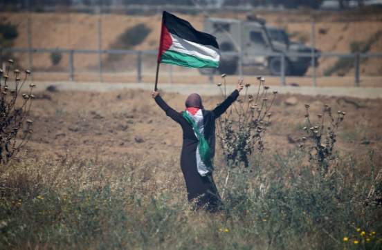 Người phụ nữ cầm cờ Palestine khi tham gia cuộc biểu tình ở phía nam Dải Gaza.