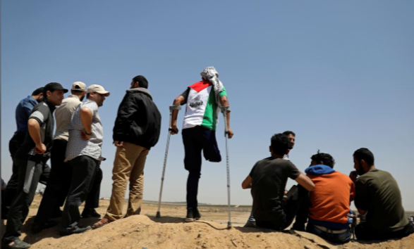 Người đàn ông Palestine chống nạng tham gia cuộc biểu tình gần hàng rào biên giới Israel-Gaza ngày 15/5.