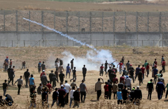 Một người biểu tình Palestine ném trả lựu đạn hơi cay về phía lực lượng an ninh Israel trong cuộc biểu tình kỷ niệm 71 năm "Ngày Thảm họa" ở phía đông thành phố Gaza hôm 15/5/2019.