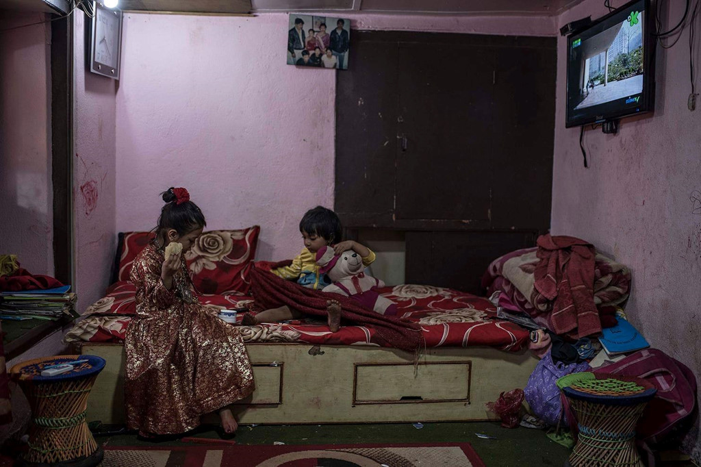 Một nữ thần mới phong của Patan đang ăn sáng với chị hoặc em mình. “Các em 3-6 tuổi khi được chọn và đến từ cộng đồng Newar, người bản xứ ở thung lũng Kathmandu. Kumari chỉ ở trong đền, chỉ có thể nói chuyện với họ hàng và một giáo viên riêng, và không được phép chạm chân xuống đất”, bà Contreras Coll nói với Washington Post. Ảnh: Maria Contreras Coll.