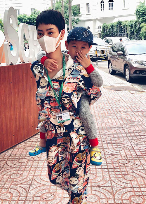 Nữ ca sĩ Trà My cõng con trai đến trường học.