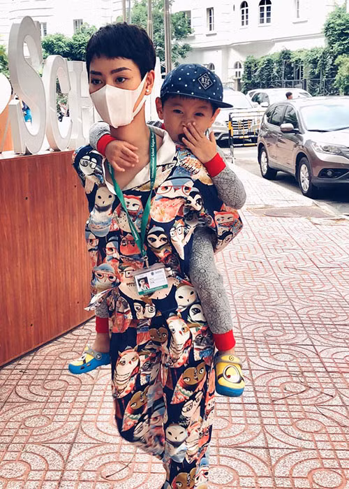 Nữ ca sĩ Trà My cõng con trai đến trường học.