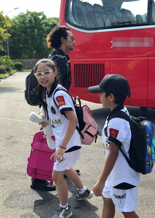 Hình ảnh Phạm Anh Khoa kéo vai li bên con gái Cào Cào và con trai Châu Chấu.