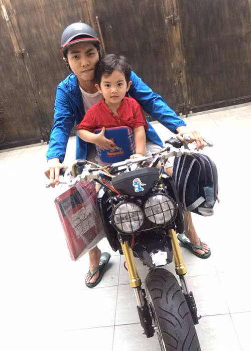 Phan Hiển đưa đón con trai đi học bằng xe mô tô.