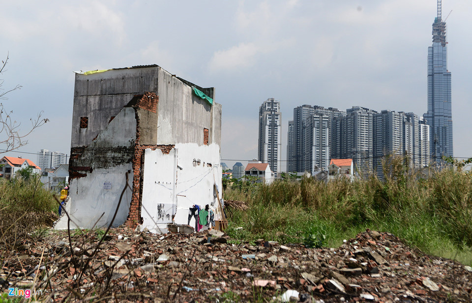 Một căn nhà nằm trơ trọi giữa um tùm lau sậy, ngổn ngang đất đá của nhà cửa đã bị đập phá thời gian qua.