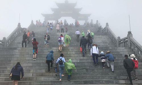 Thời tiết se lạnh kèm sương mù nên nhiều người phải mặc cả áo mưa, áo phao chống rét.