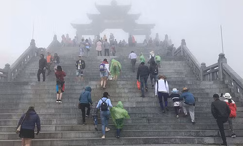 Thời tiết se lạnh kèm sương mù nên nhiều người phải mặc cả áo mưa, áo phao chống rét.