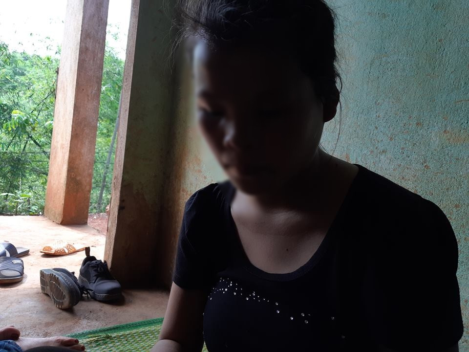 Bé M. lặng lẽ ngồi trong nhà.