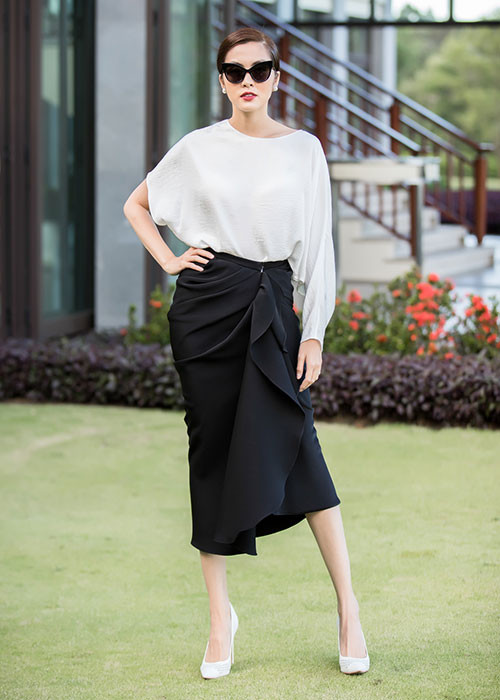 Hà Tăng diện trang phục trắng đen, tô son đỏ quyến rũ và búi tóc gọn gàng.