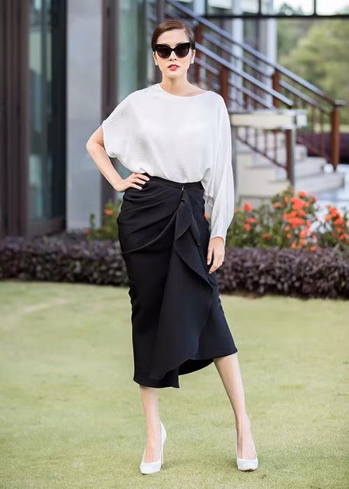 Hà Tăng diện trang phục trắng đen, tô son đỏ quyến rũ và búi tóc gọn gàng.