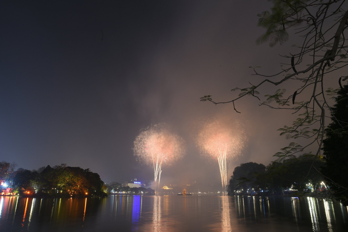 Đúng 0h ngày 22/1, pháo hoa chào đón năm mới đồng loạt thắp sáng bầu trời cả nước tại nhiều điểm ở Thủ đô Hà Nội, TPHCM và các nhiều tỉnh, thành. Ảnh: Chùm pháo hoa rực rỡ trên bầu trời Hà Nội