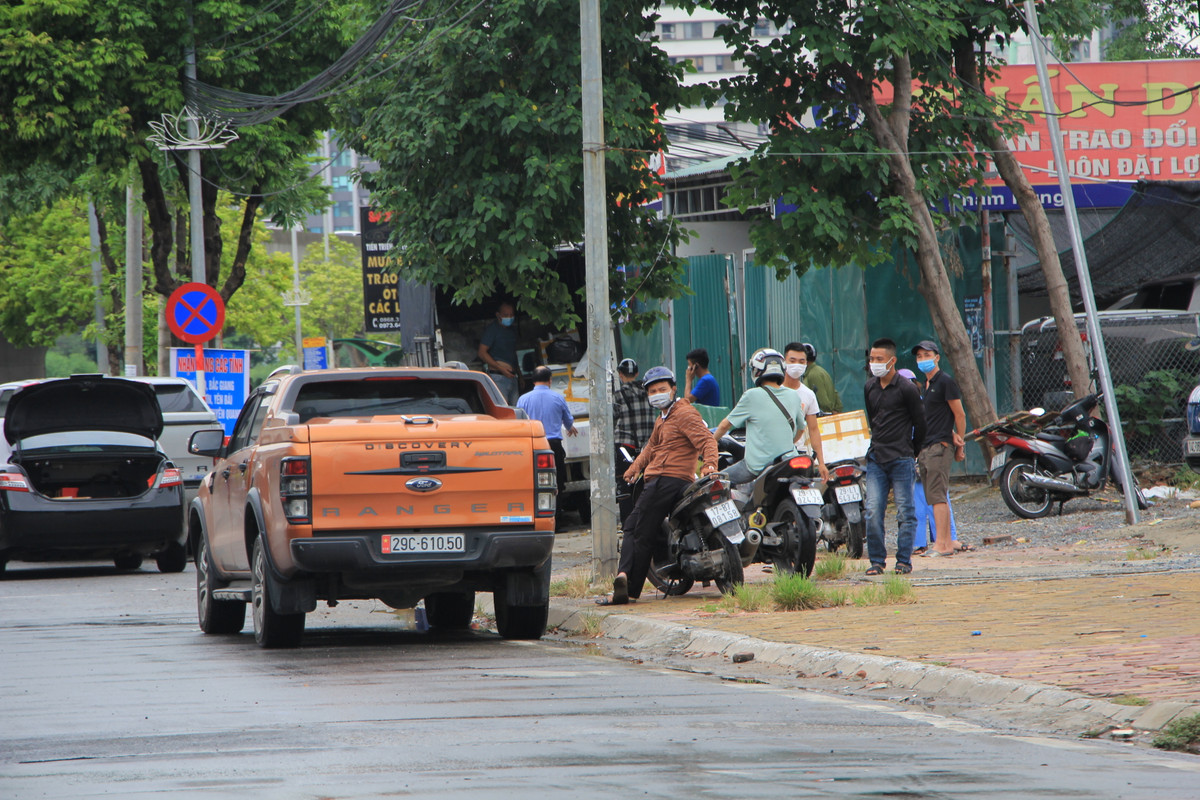 Việc bốc xếp, đổ hàng của những chiếc xe này ngay trên đường Phạm Hùng tập trung đông người, không tuân thủ quy định giãn cách.