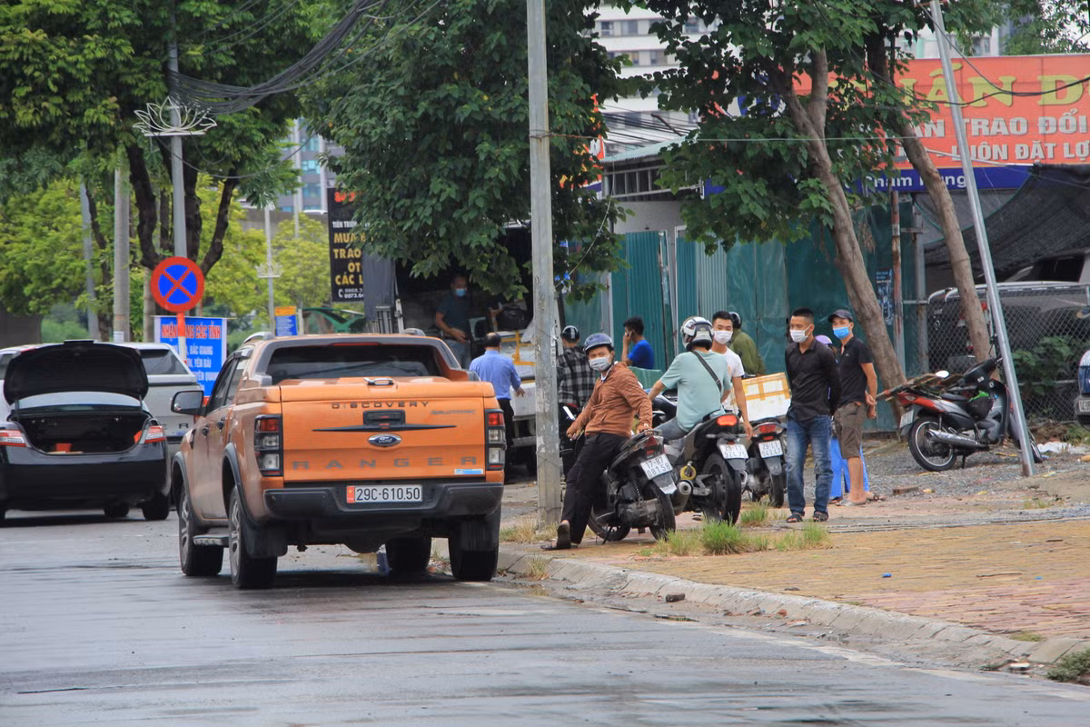 Việc bốc xếp, đổ hàng của những chiếc xe này ngay trên đường Phạm Hùng tập trung đông người, không tuân thủ quy định giãn cách.