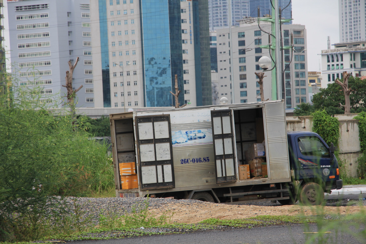 Chiếc xe vẫn nằm chờ chủ hàng ra lấy. Nếu không có sự chỉ đường tận tình của lái, phụ xe thì chủ hàng khó có thể tìm được bãi đất rậm rạp cây dại này, mặc dù nằm sát đường Phạm Hùng (quận Cầu Giấy).