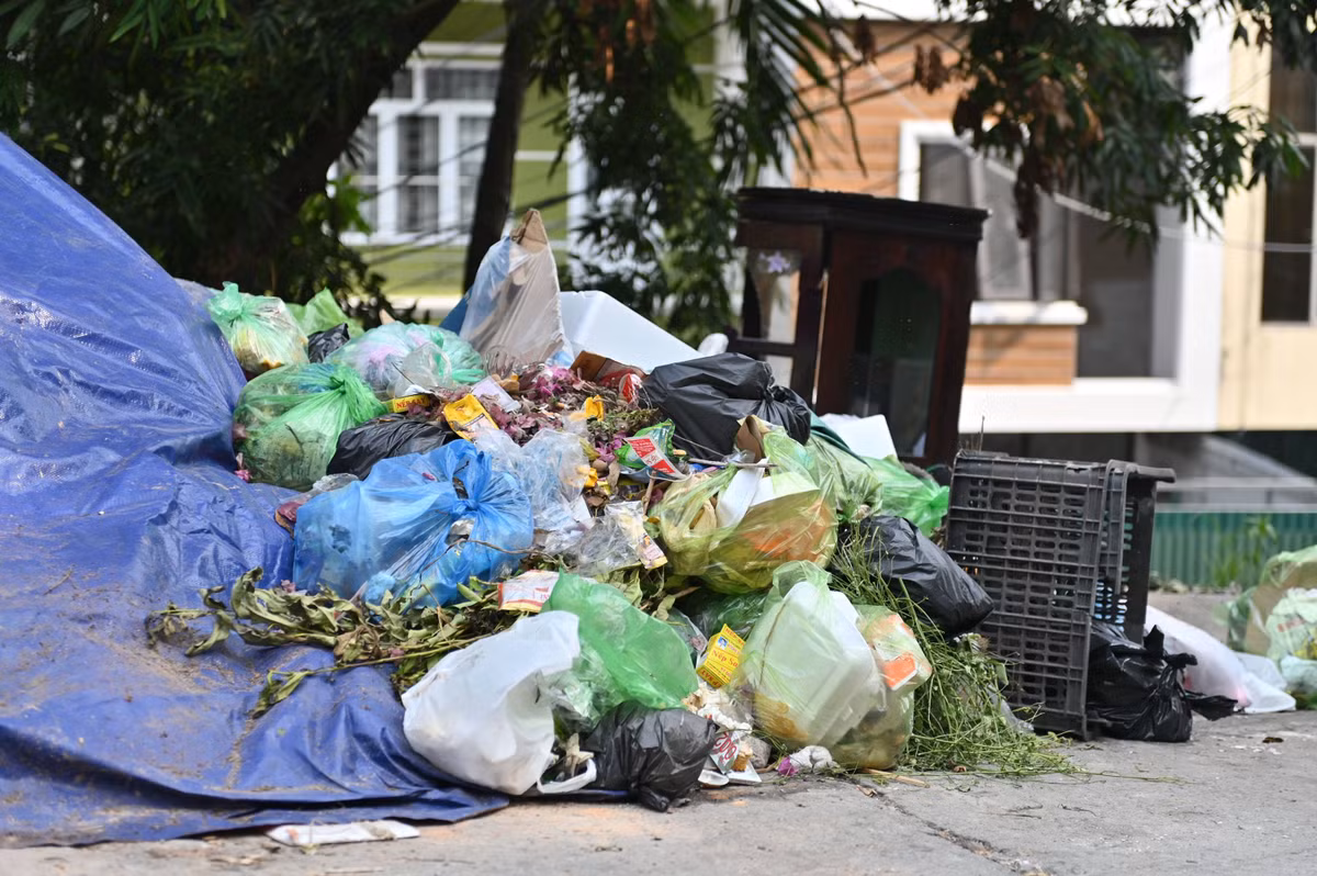 Sau khi được phủ bạt, rác lại tiếp tục được xếp chồng lên trên.