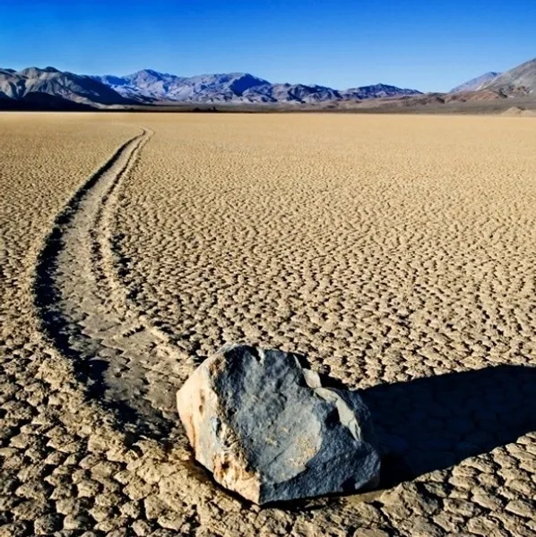1. Đá chuyển động ở Thung lũng Chết: Thung lũng Chết ở California, Mỹ, là nơi nổi tiếng với những tảng đá tự di chuyển trên mặt đất phẳng mà không có sự can thiệp nào của con người hay động vật. Những vệt dài trên mặt đất chứng minh rằng các tảng đá này đã di chuyển một quãng đường dài, nhưng cách chúng di chuyển vẫn là một bí ẩn. Một số nhà khoa học cho rằng hiện tượng lạ lùng này có thể liên quan đến lớp băng mỏng hình thành dưới đá, nhưng vẫn chưa có lời giải thích nào hoàn toàn thuyết phục. (Ảnh: sailingstone)