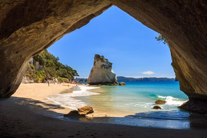 5. Hang động Cathedral Cove - New Zealand: Cathedral Cove, nằm trên bán đảo Coromandel, New Zealand, là một trong những hang động biển đẹp nhất thế giới với hình dáng giống như một mái vòm khổng lồ. Nước biển xanh biếc, bờ cát trắng mịn, cùng cảnh quan thiên nhiên xung quanh tạo nên một bức tranh hoàn hảo, thu hút không ít khách du lịch và những người yêu thích nhiếp ảnh.(Ảnh: Viator)