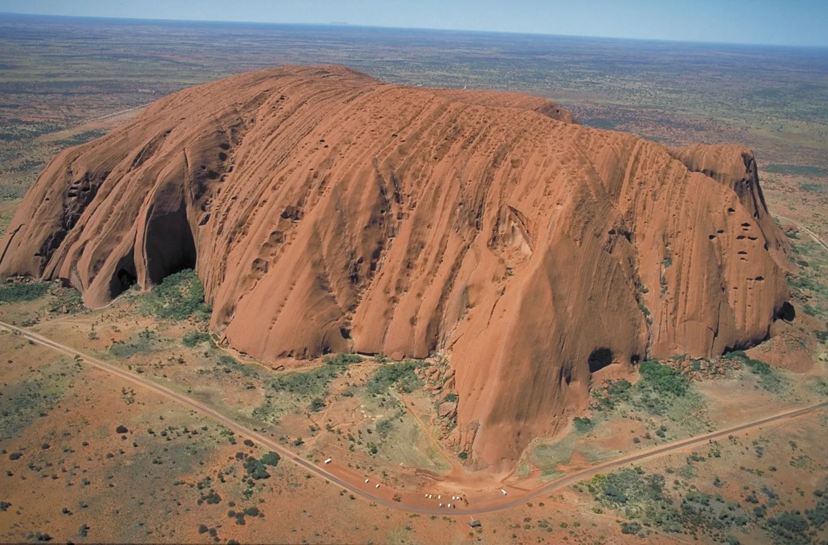 8. Tảng đá Uluru (Ayers Rock) - Úc: Uluru, còn được gọi là Ayers Rock, là một trong những tảng đá nguyên khối lớn nhất và nổi tiếng nhất thế giới. Nằm ở trung tâm nước Úc, Uluru cao 348 mét và có chu vi khoảng 9,4 km. Tảng đá này được biết đến với khả năng thay đổi màu sắc theo thời gian trong ngày, từ màu đỏ rực rỡ vào buổi sáng sớm đến màu cam và tím vào lúc hoàng hôn. Uluru cũng là một địa điểm linh thiêng của người thổ dân Anangu, với nhiều truyền thuyết và câu chuyện văn hóa gắn liền với nó.(Ảnh: Britannica)