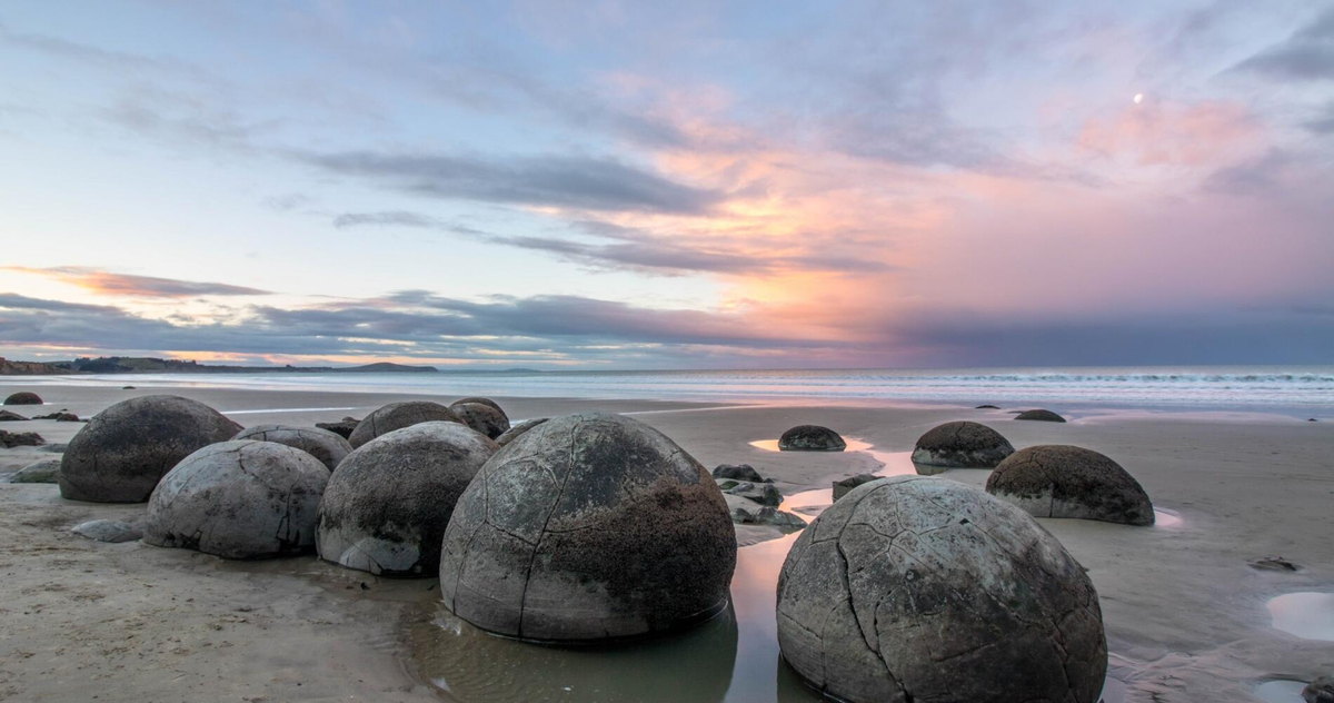 4. Tảng đá Moeraki Boulders - New Zealand: Những tảng đá Moeraki Boulders nằm rải rác trên bờ biển Koekohe ở New Zealand nổi tiếng với hình dạng tròn hoàn hảo như những quả bóng khổng lồ. Được hình thành từ bùn đất và các trầm tích biển hàng triệu năm trước, những tảng đá này có đường kính từ 1,5 đến 2,2 mét và được cho là kết quả của quá trình kết tinh tự nhiên dưới biển. (Ảnh:New Zealand)