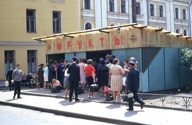 Người dân đợi bên ngoài để chờ mua rau củ tại một quầy thực phẩm.