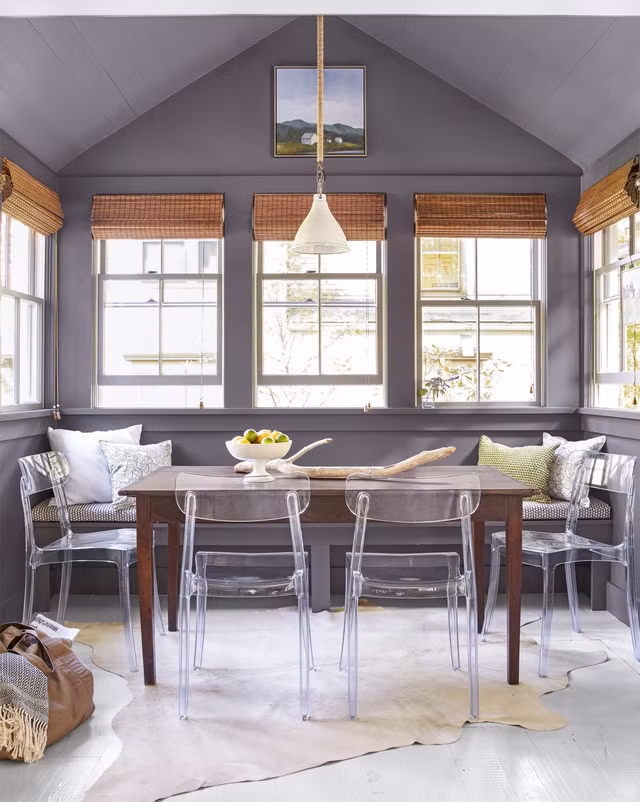 Phòng ăn được sơn bằng màu chì than nhạt – gam màu trung tính nhưng nhờ có những ô cửa sổ lớn mà vẫn rất tươi sáng. Không gian bên dưới bệ cửa sổ được tận dụng để làm một chiếc ghế băng giúp cung cấp thêm nhiều chỗ ngồi hơn, những chiếc ghế nhựa trong suốt mang nét hiện đại và tạo độ thông thoáng cho không gian hơn rất nhiều so với những chiếc ghế gỗ cổ điển. Ảnh: Countryliving.