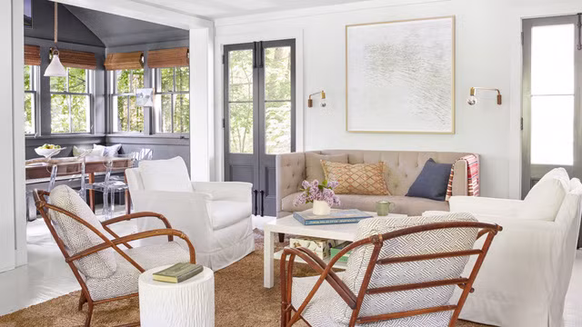 Sự kết hợp của những chiếc ghế mây và những chiếc nệm ngồi đa dạng đã tạo nên phong cách chiết trung độc đáo cho không gian. Chiếc ghế sofa Chesterfield lại rất phù hợp với những cánh cửa kiểu Pháp. Ảnh: Countryliving.