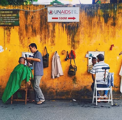 Khi đến Hà Nội, du khách vẫn bắt gặp hình ảnh những quán cắt tóc vỉa hè. Trong ảnh là quán cắt tóc vỉa hè trên phố Trịnh Hoài Đức, Hà Nội.