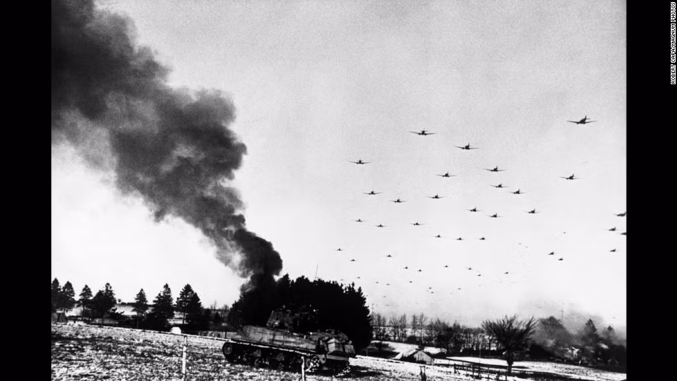 Một xe tăng của quân đội Mỹ bị thiêu rụi. Bên trên là những máy bay bay rợp trời Bulge.