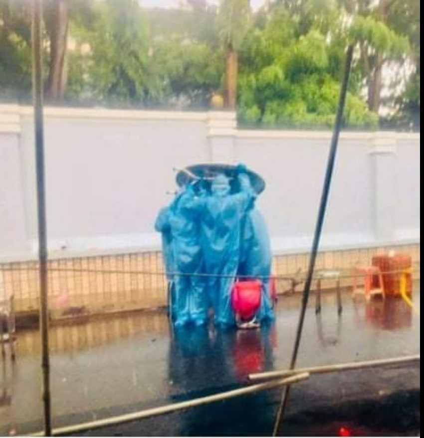 Những tình nguyện viên trong đội lấy mẫu cộng đồng tại Thủ Đức, TP HCM đang tìm cách bảo vệ các mẫu xét nghiệm dưới cơn mưa. Ảnh: Tổng hợp