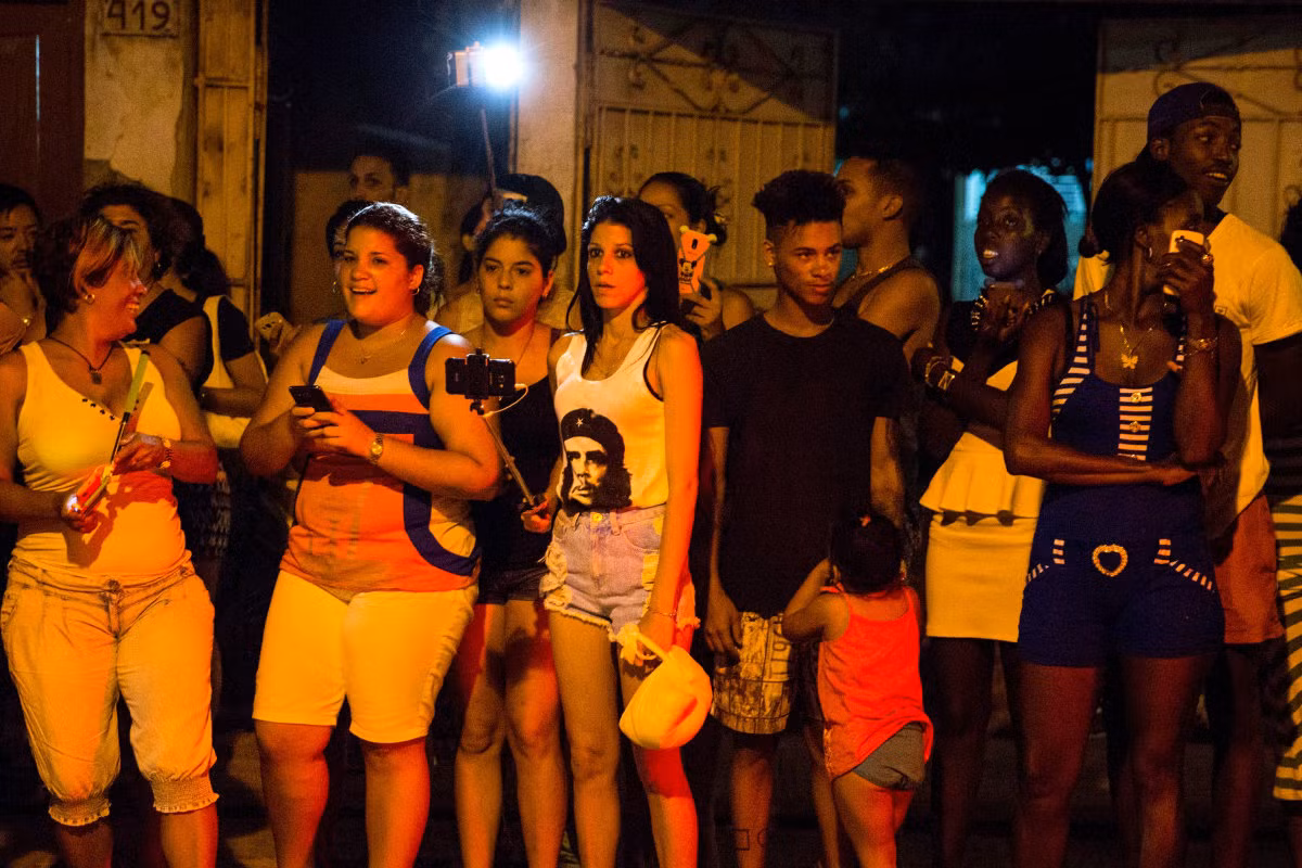 Nhiều người đứng bên ngoài một nhà hàng ở thủ đô La Habana để chờ đón nữ danh ca Madonna. Ảnh USN