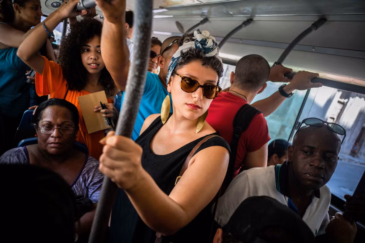 Công dân Mỹ gốc Cuba Fontaine Capel (giữa) đi trên tuyến xe buýt ở La Habana. Capel quyết định trở về quê nhà Cuba để thực hiện CubaOne, một dự án mới được thúc đẩy bởi việc tái lập quan hệ ngoại giao và thương mại giữa Mỹ và Cuba. Ảnh USN