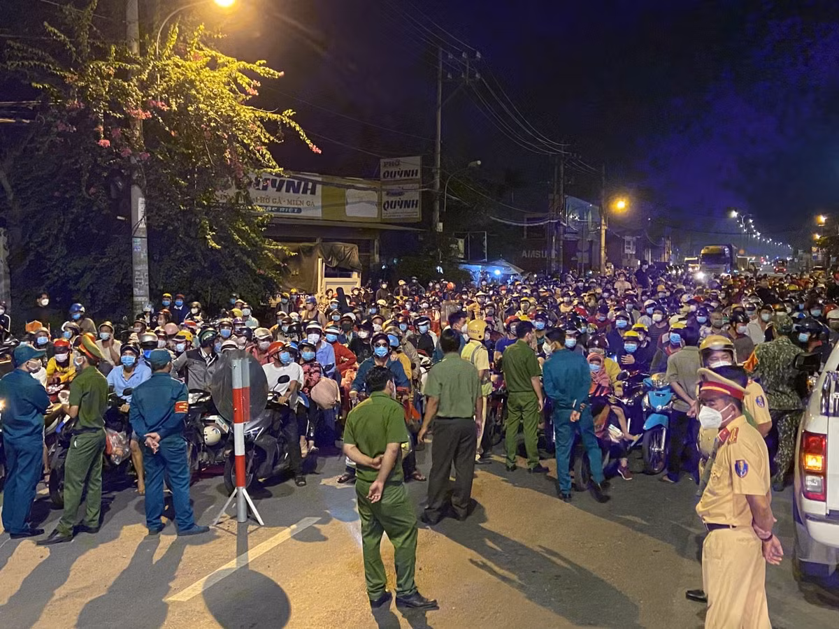 Lực lượng chức năng tuyên truyền, yêu cầu người dân quay về nơi cư trú; tuy nhiên, nhiều người vẫn cố bám trụ, chờ được thông qua để về nhà. Ảnh TTX.