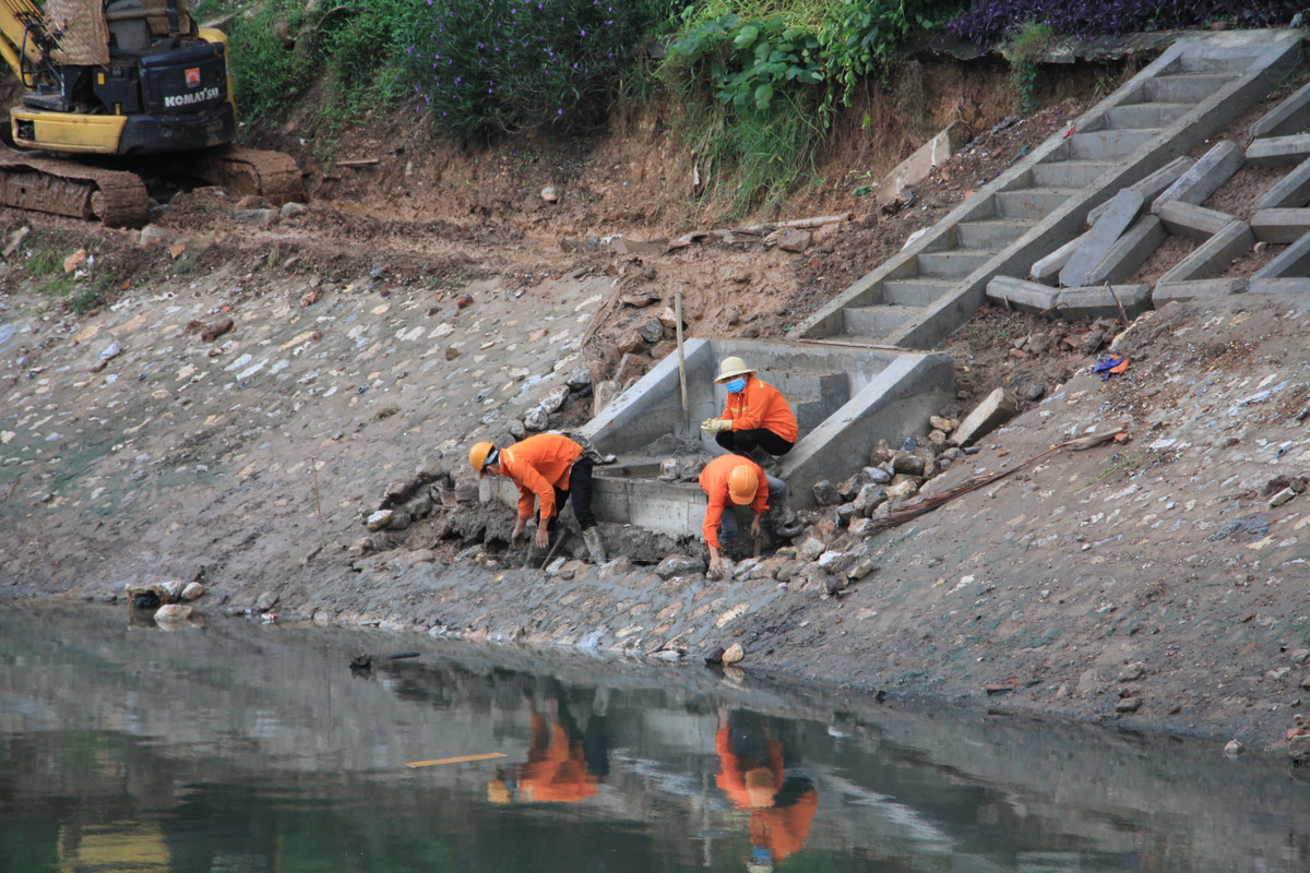Nhóm công nhân "cam chịu" cảnh vừa ngửi mùi hôi thối vừa thi công.