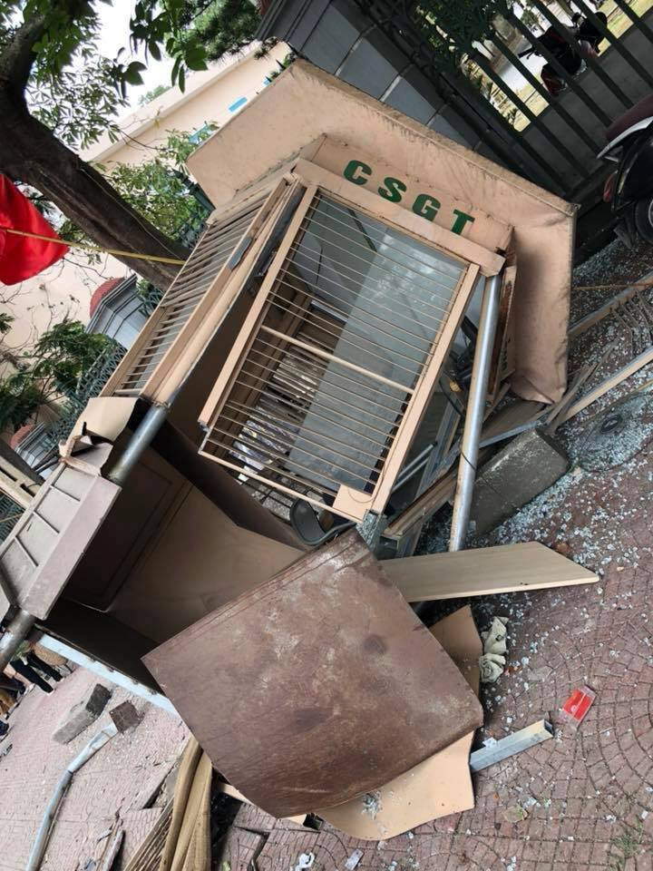 Cột đèn tín hiệu bị gẫy đôi, bốt công an biến dạng, phần đầu xe tải hư hỏng nặng.