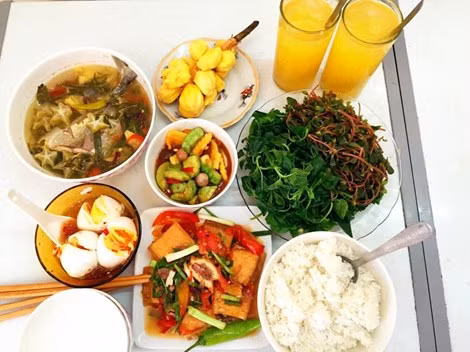 Một phần ăn siêu rẻ và tốt cho sức khỏe với đậu phụ nhồi thịt sốt cà chua, trứng luộc dầm nước mắm, canh chua cá khế, rau sau và rau dền luộc, tráng miệng mít tố nữ và nước ép cam.