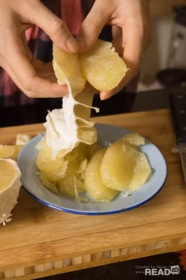 Bước 4: Tách đôi quả bưởi, lấy dao sắc cắt đứt phần lõi giữa các múi bưởi, sau đó lần lượt bóc từng lớp vỏ bưởi tách múi ra. Sau đó tiếp tục bóc lớp vỏ thứ 2, tách múi thứ 2 cho đến hết.