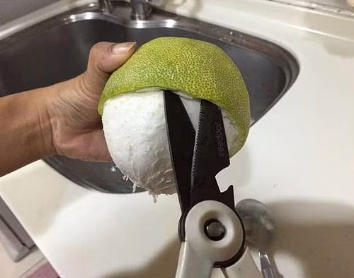 Bước 3: Tiếp tục lấy mũi thìa hoặc mũi kéo đẩy vào và tách nốt lớp viền của 2/3 vỏ bưởi còn lại giống bước 2.