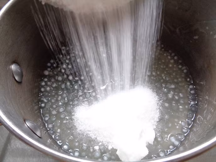 Bước 2: Cho bột rau câu dẻo, đường, nước lá dứa cho vào nồi hòa tan, sau đó bắc lên bếp đun nhỏ lửa cho nước thạch sôi đường tan hoàn toàn thì tắt bếp. Đổ thạch ra khay hoặc hộp để nguội rồi cho vào ngăn mát tủ lạnh cho thạch đông lại. Khi thạch đông thì lấy ra cắt miếng vuông nhỏ.