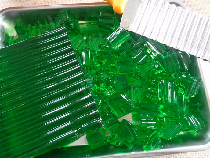 Nguyên liệu của món chè thạch dừa non: 4,5g bột rau câu dẻo, 500ml nước lá dứa, 30g đường, 100g bột báng, 300ml nước, 100g đường, 1 quả dừa non, 400ml nước cốt dừa.