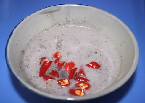 Cuối cùng đổ đầu ăn vào bát, thêm ớt thái lát vào tới khi vị cay vừa miệng là được.