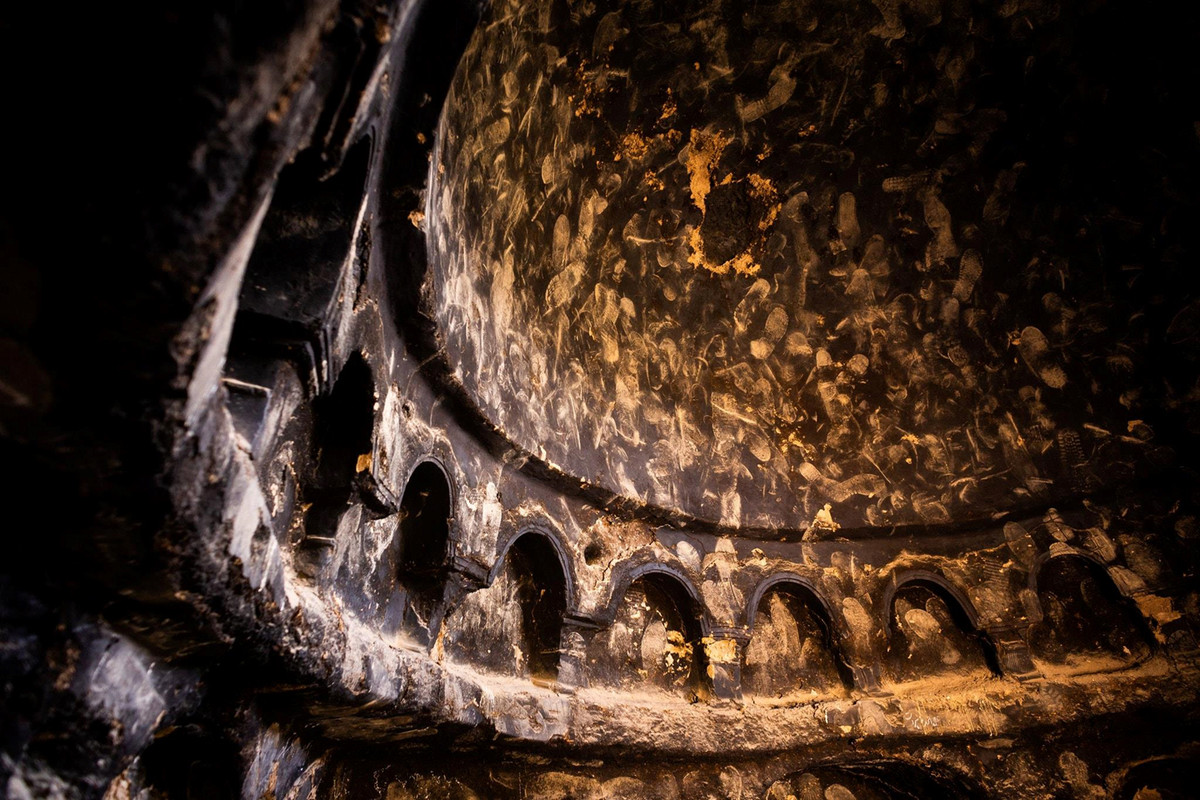 Vào những năm 1990, những hang động trong tổ hợp Bamiyan là nơi trú ẩn của các chiến binh Hồi giáo và họ đốt củi để sưởi ấm. Khói bay lên ám đen các hang động, vì là những người Hồi giáo cực đoan, họ đạp lên bức tường các hang động để bày tỏ sự bất kính. Ảnh: New York Times. 