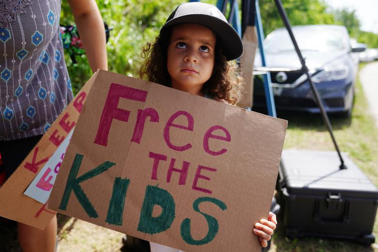 Một bé gái cầm tấm biển thể hiện sự ủng hộ đối với những đứa trẻ nhập cư trong trung tâm Homestead.
