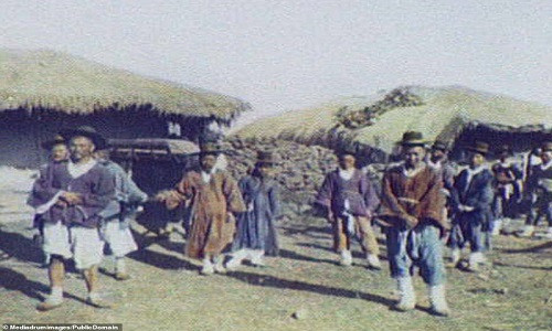 Một quan chức địa phương (ngồi trong kiệu) và đoàn tùy tùng dừng chân tại một ngôi làng.