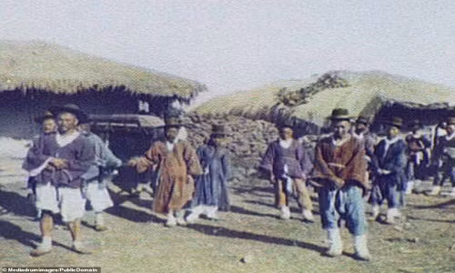 Một quan chức địa phương (ngồi trong kiệu) và đoàn tùy tùng dừng chân tại một ngôi làng.