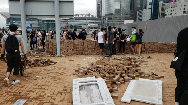 Nhiều người biểu tình cạy gạch khỏi vỉa hè và xếp thành tường bên ngoài các cơ quan công quyền ở Hong Kong.